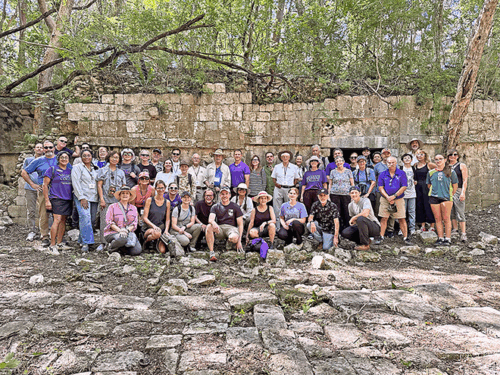 Picture of large group of people standing in front of Mayan ruins.
